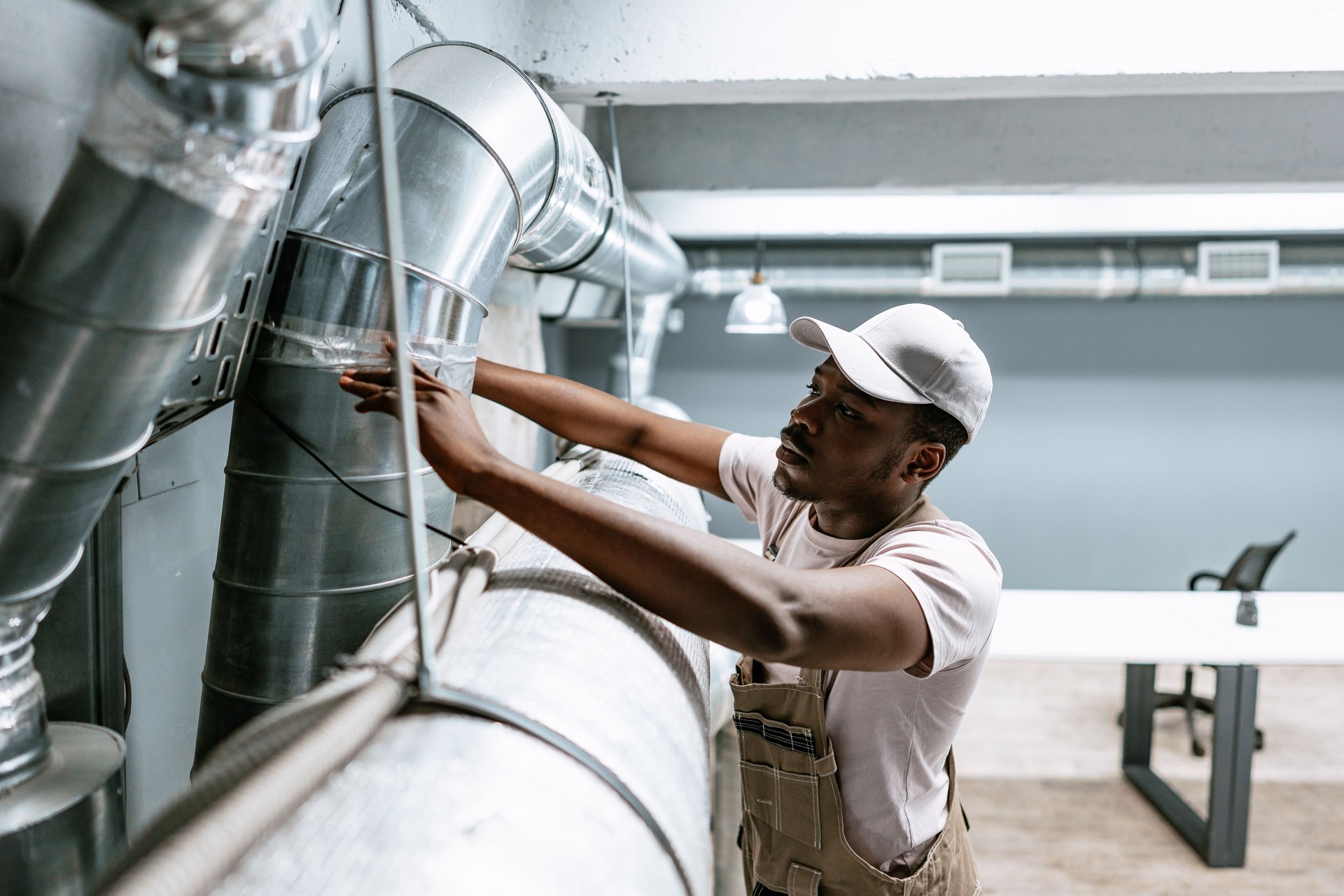 Technician inspects ventilation system in modern office environment during maintenance work